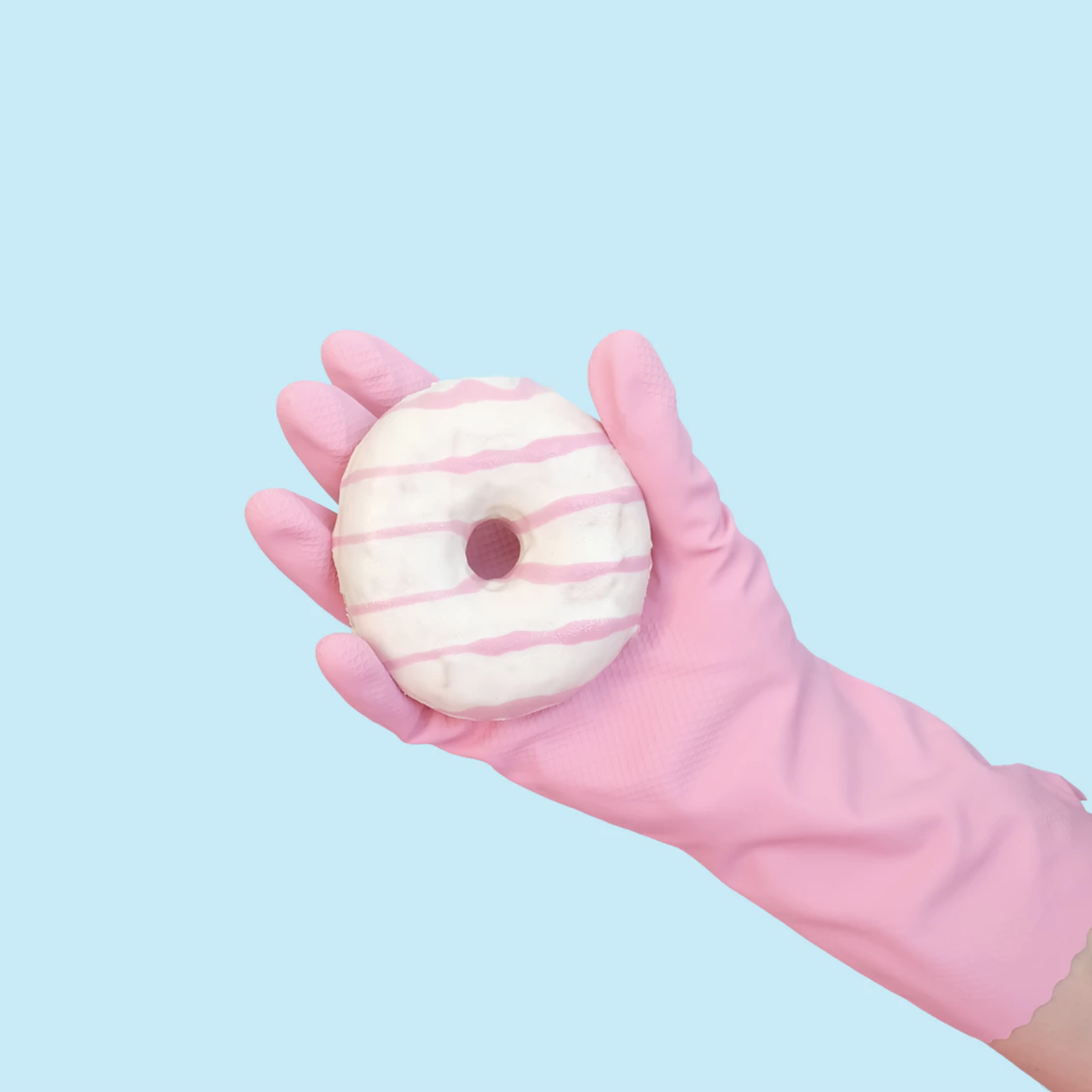 A gloved hand holding a donut.